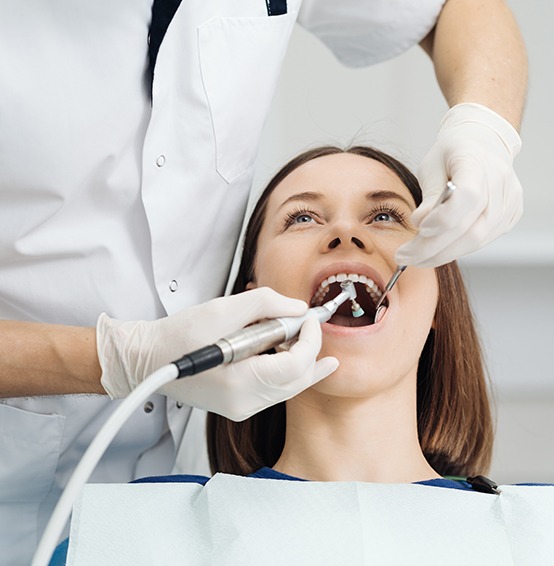 Female patient receiving a dental checkup and cleaning