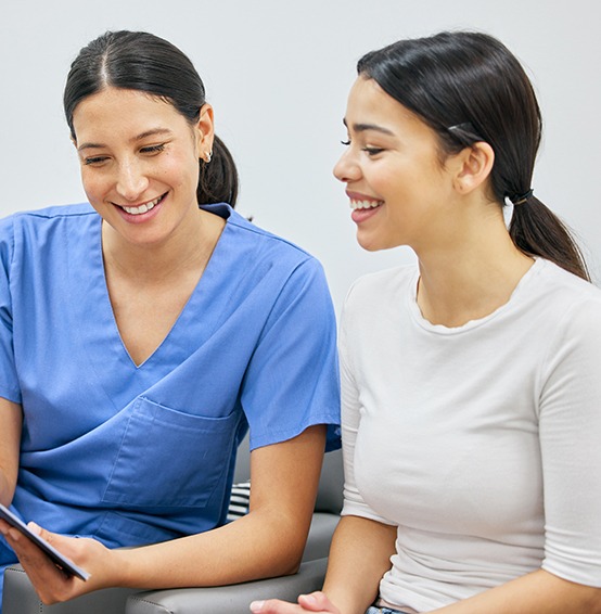 Female patient talking to dental staff member about insurance