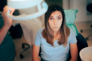Dental patient looking like she’s been caught at something.